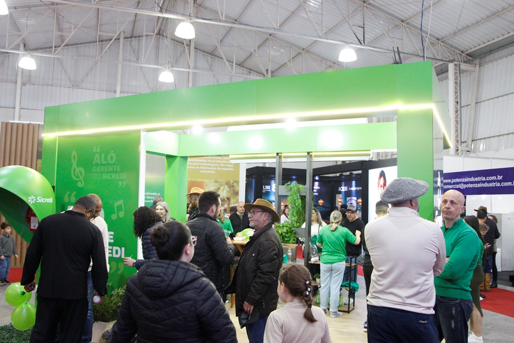 Visitantes observam um estande verde na feira